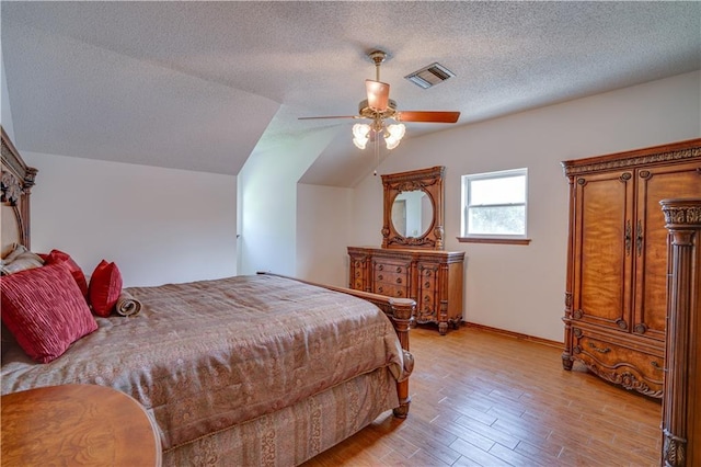 119 Gondrella Dr, Belle Chasse, LA 70037 - bedroom featuring vaulted ceiling, light wood-style floors, a textured ceiling, and ceiling fan