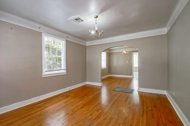 157 Gruner Rd, Metairie, LA 70001 - unfurnished room featuring arched walkways, a chandelier, and light wood-style floors