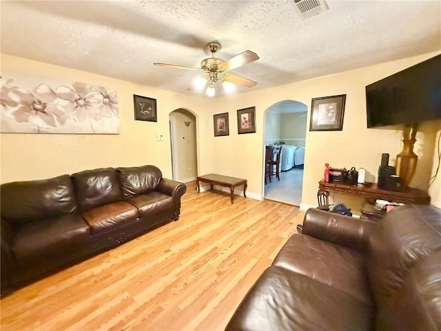 632 Eiseman St, Marrero, LA 70072 - living room featuring arched walkways, light wood-style floors, a ceiling fan, and a textured ceiling
