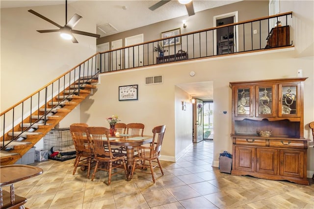 1500 Madewood Rd, La Place, LA 70068 - dining room featuring ceiling fan, stairs, a towering ceiling, and tile patterned flooring