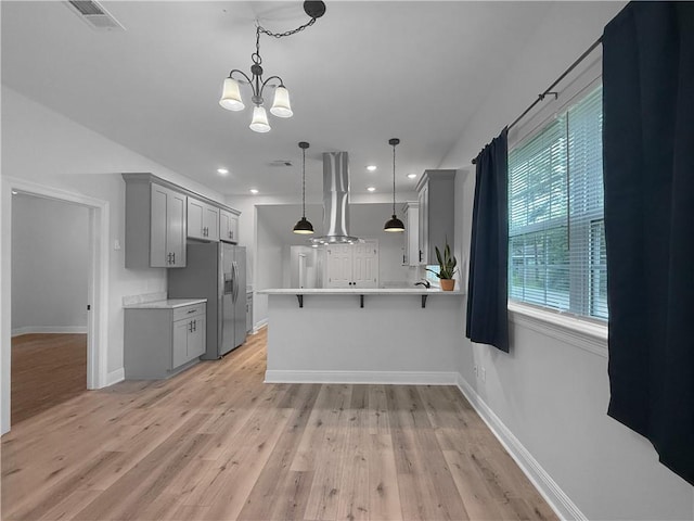 200 N Steele Ave, Picayune, MS 39466 - kitchen featuring gray cabinets, stainless steel fridge with ice dispenser, extractor fan, light countertops, and recessed lighting