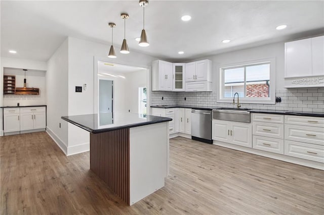 57 Driftwood Blvd, Kenner, LA 70065 - kitchen featuring stainless steel dishwasher, light wood-style floors, backsplash, dark countertops, and white cabinetry