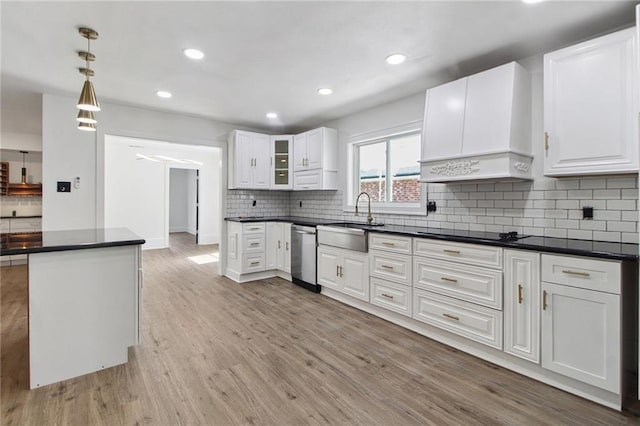 57 Driftwood Blvd, Kenner, LA 70065 - kitchen featuring premium range hood, dishwasher, dark countertops, light wood-style flooring, and white cabinetry