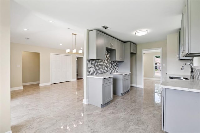 4742 Virgilian St, New Orleans, LA 70126 - kitchen featuring gray cabinetry, backsplash, light marble finish floors, and recessed lighting