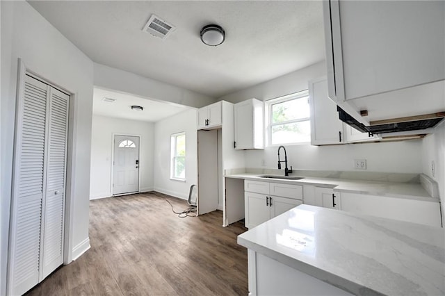 9126 Dixon St, New Orleans, LA 70118 - kitchen with wood finished floors and white cabinetry