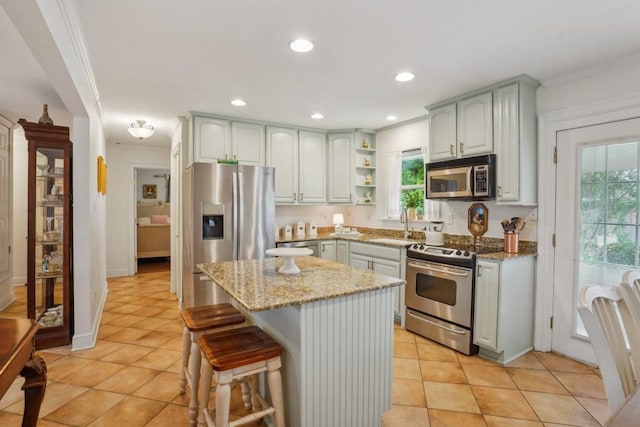 4320 Academy Dr, Metairie, LA 70003 - kitchen featuring stainless steel appliances, light stone counters, light tile patterned flooring, ornamental molding, and open shelves