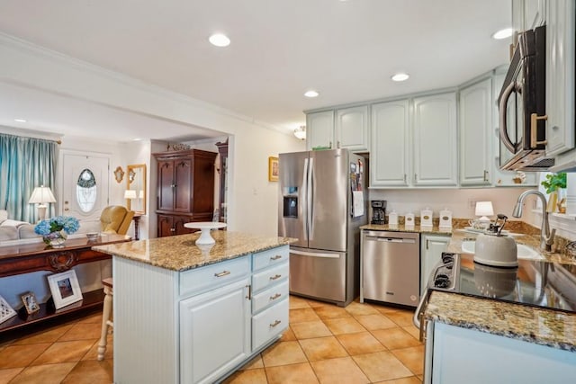 4320 Academy Dr, Metairie, LA 70003 - kitchen with stainless steel appliances, open floor plan, ornamental molding, light stone counters, and a kitchen island