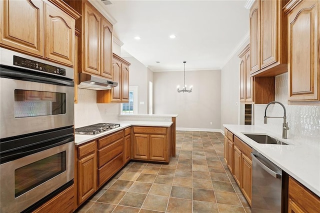319 Red Maple Dr, Mandeville, LA 70448 - kitchen with stainless steel appliances, tasteful backsplash, ornamental molding, a chandelier, and light countertops
