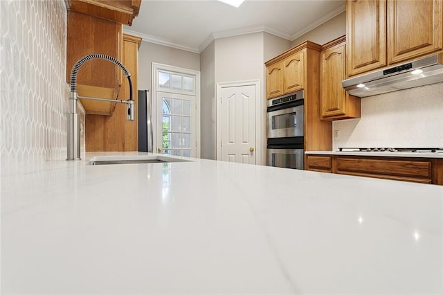 319 Red Maple Dr, Mandeville, LA 70448 - kitchen featuring under cabinet range hood, double oven, gas cooktop, light countertops, and crown molding