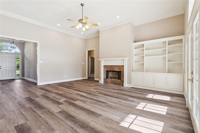 319 Red Maple Dr, Mandeville, LA 70448 - unfurnished living room featuring wood finished floors, a ceiling fan, crown molding, recessed lighting, and a tiled fireplace