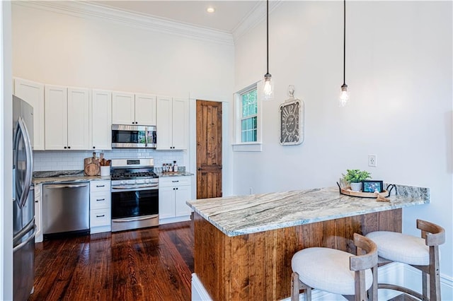 2546 Onzaga St, New Orleans, LA 70119 - kitchen featuring stainless steel appliances, a peninsula, light stone counters, crown molding, and backsplash