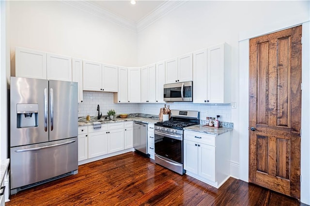2546 Onzaga St, New Orleans, LA 70119 - kitchen with appliances with stainless steel finishes, crown molding, light stone countertops, backsplash, and dark wood-style flooring
