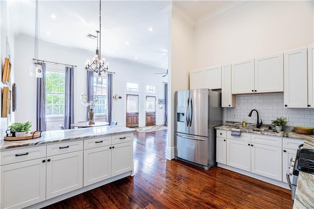 2546 Onzaga St, New Orleans, LA 70119 - kitchen featuring appliances with stainless steel finishes, a chandelier, tasteful backsplash, crown molding, and dark wood-style flooring