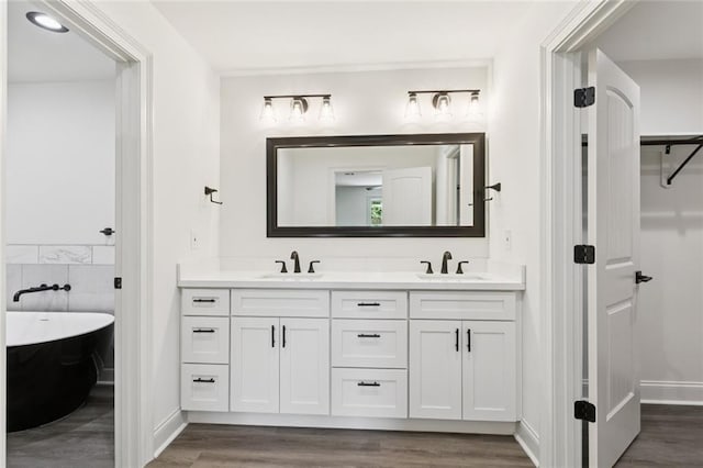 12 Fairlane Dr, Metairie, LA 70003 - full bathroom featuring wood finished floors, double vanity, and a freestanding bath