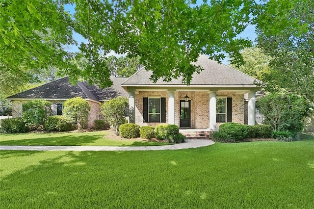 217 Sap Berry Dr, Madisonville, LA 70447 - view of front of house featuring brick siding, covered porch, a front lawn, and roof with shingles