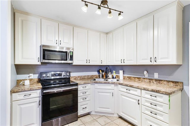 82 Packenham Ave, Chalmette, LA 70043 - kitchen featuring appliances with stainless steel finishes, light tile patterned floors, white cabinets, and light countertops