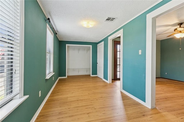 202 Amelia St, Destrehan, LA 70047 - hallway with light wood finished floors, a textured ceiling, and crown molding