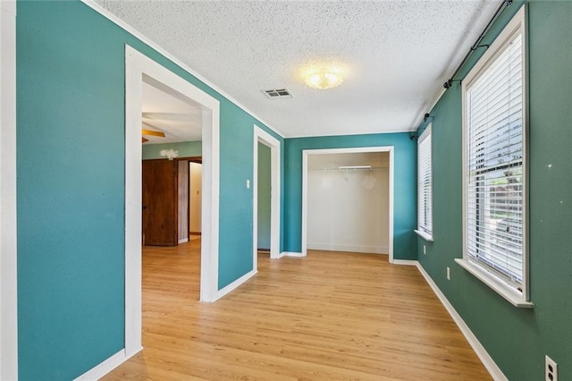 202 Amelia St, Destrehan, LA 70047 - hall with a textured ceiling, a barn door, light wood-style floors, and ornamental molding