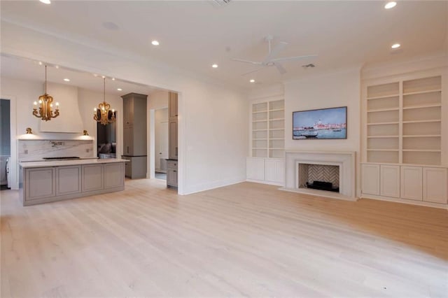 209 Avenue E Ave E, Metairie, LA 70005 - unfurnished living room with a chandelier, ceiling fan, light wood finished floors, recessed lighting, and a fireplace