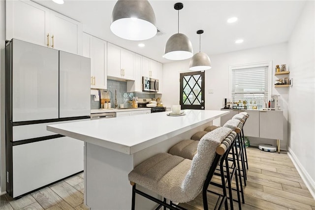 2900 Somerset Dr, New Orleans, LA 70131 - kitchen featuring appliances with stainless steel finishes, a kitchen bar, light countertops, white cabinetry, and recessed lighting