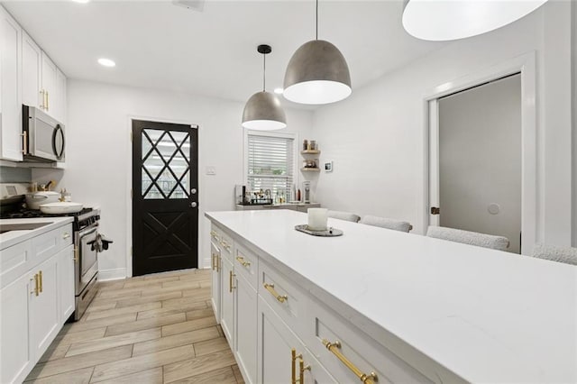 2900 Somerset Dr, New Orleans, LA 70131 - kitchen featuring stainless steel gas range oven, white cabinetry, hanging light fixtures, light wood finished floors, and recessed lighting