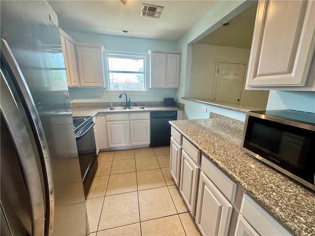 3509 Decomine Dr, Chalmette, LA 70043 - kitchen featuring appliances with stainless steel finishes, white cabinetry, light tile patterned flooring, and light stone counters