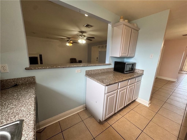3509 Decomine Dr, Chalmette, LA 70043 - kitchen with light tile patterned flooring, a ceiling fan, and stone countertops