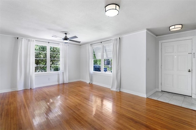 53 Beverly Garden Dr, Metairie, LA 70001 - empty room with healthy amount of natural light, a textured ceiling, a ceiling fan, light wood finished floors, and crown molding