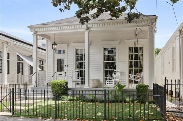 1123 Cadiz St, New Orleans, LA 70115 - view of front of house featuring a porch, a fenced front yard, and roof with shingles