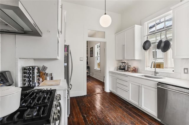 1123 Cadiz St, New Orleans, LA 70115 - kitchen with appliances with stainless steel finishes, ventilation hood, dark wood finished floors, light countertops, and white cabinetry