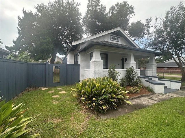 1401 Jefferson St, Gretna, LA 70053 - view of side of property featuring brick siding, a gate, and covered porch