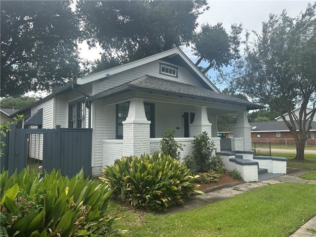 1401 Jefferson St, Gretna, LA 70053 - view of front facade with covered porch, brick siding, and a shingled roof