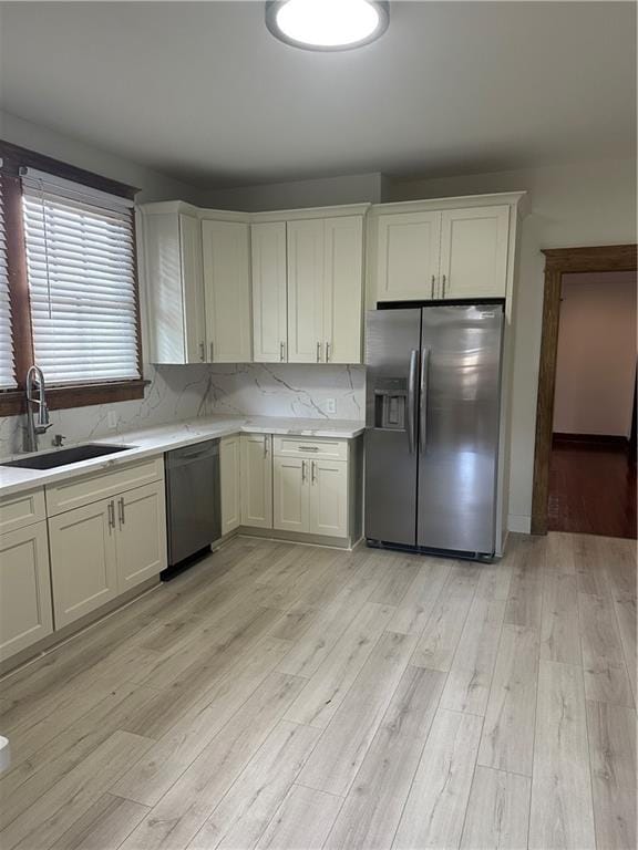 1401 Jefferson St, Gretna, LA 70053 - kitchen with stainless steel appliances, light wood finished floors, white cabinetry, and tasteful backsplash