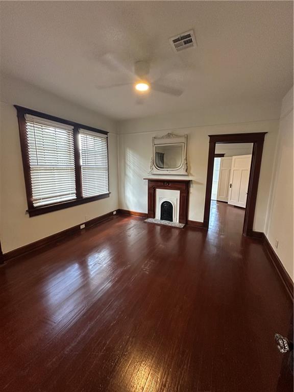 1401 Jefferson St, Gretna, LA 70053 - unfurnished living room featuring ceiling fan, dark wood-type flooring, and a fireplace with flush hearth