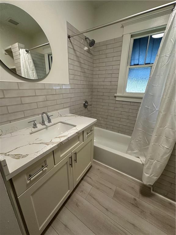 1401 Jefferson St, Gretna, LA 70053 - bathroom featuring vanity, shower / tub combo with curtain, and wood tiled floors