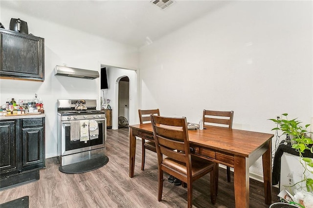 1640 Poland Ave, New Orleans, LA 70117 - kitchen with stainless steel gas range, range hood, arched walkways, wood finished floors, and light countertops