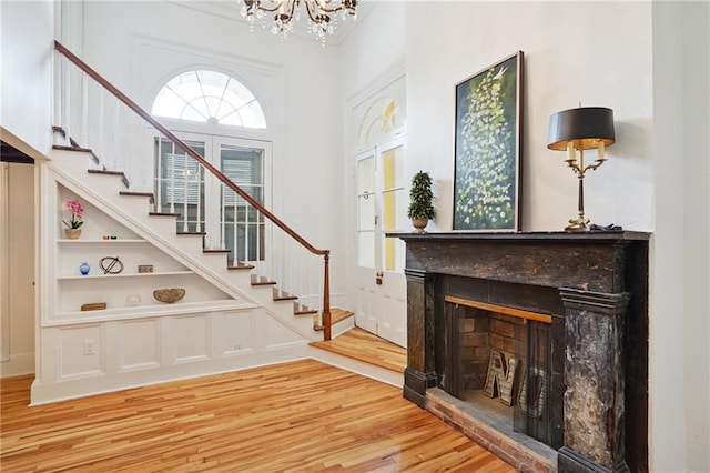 1303 Burgundy St Unit 3, New Orleans, LA 70116 - entryway with a chandelier, wood finished floors, a fireplace with raised hearth, and plenty of natural light