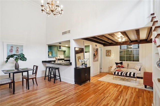1303 Burgundy St Unit 3, New Orleans, LA 70116 - living room featuring light wood finished floors, a chandelier, and beamed ceiling