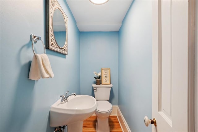 1303 Burgundy St Unit 3, New Orleans, LA 70116 - half bathroom with toilet and wood finished floors