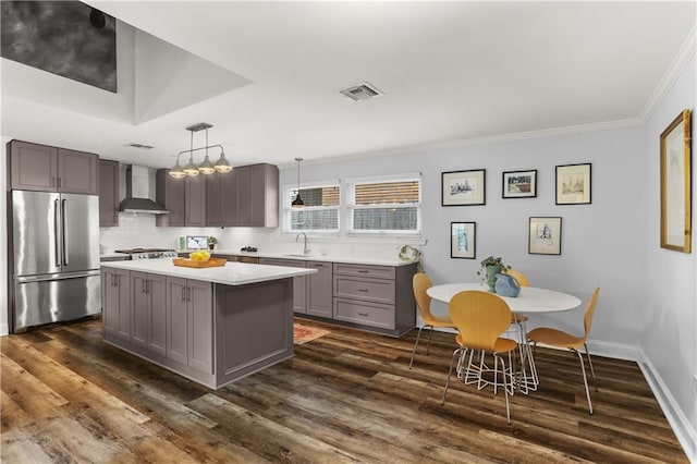 159 Valerie St, River Ridge, LA 70123 - kitchen featuring high end refrigerator, gray cabinets, wall chimney exhaust hood, ornamental molding, and light countertops