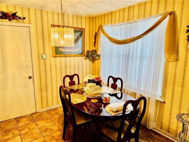 6655 Dalark Dr, Baton Rouge, LA 70812 - dining space featuring wallpapered walls, a textured ceiling, and a chandelier