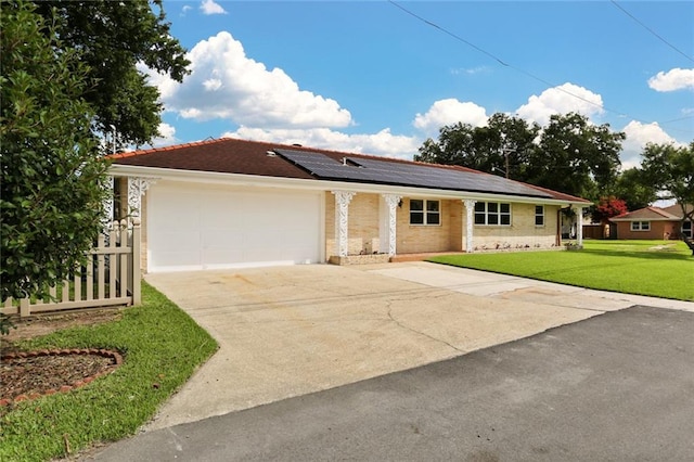 40 Holly Dr, Gretna, LA 70053 - ranch-style home with a garage, roof mounted solar panels, concrete driveway, and brick siding