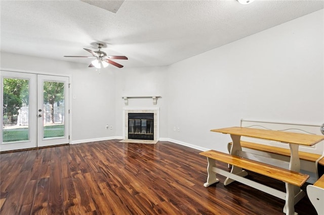 108 Parkview Blvd Unit 108, Mandeville, LA 70471 - unfurnished living room with wood finished floors, ceiling fan, a tile fireplace, french doors, and a textured ceiling