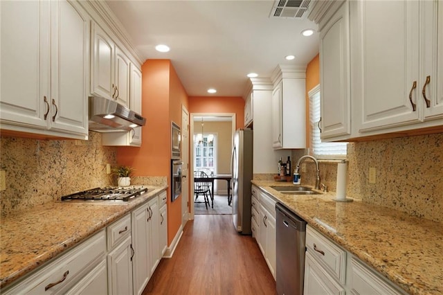4740 Avron Blvd, Metairie, LA 70006 - kitchen featuring stainless steel appliances, wood finished floors, under cabinet range hood, healthy amount of natural light, and recessed lighting