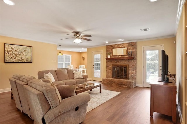 4740 Avron Blvd, Metairie, LA 70006 - living area with wood finished floors, ceiling fan, crown molding, recessed lighting, and a brick fireplace