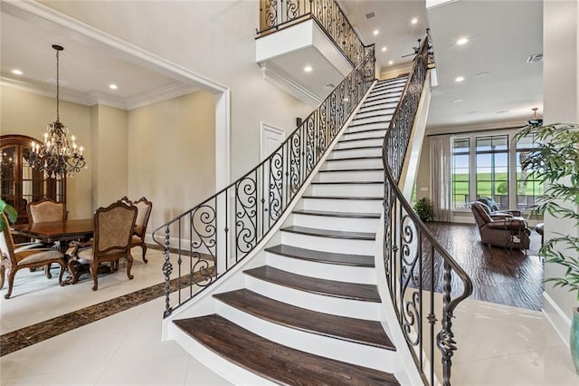 24 Royal Palm Dr, Kenner, LA 70065 - staircase featuring crown molding, a chandelier, recessed lighting, tile patterned flooring, and a high ceiling