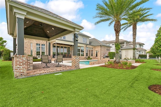 24 Royal Palm Dr, Kenner, LA 70065 - back of house with a ceiling fan, a patio area, a yard, an outdoor pool, and brick siding