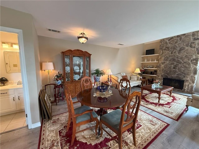 4135 Loire Dr Unit B, Kenner, LA 70065 - dining room with light wood-type flooring and a stone fireplace