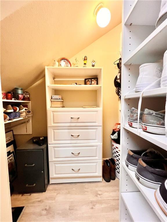 146 Emerald Oaks Dr, Covington, LA 70433 - walk in closet with vaulted ceiling and light wood-style floors