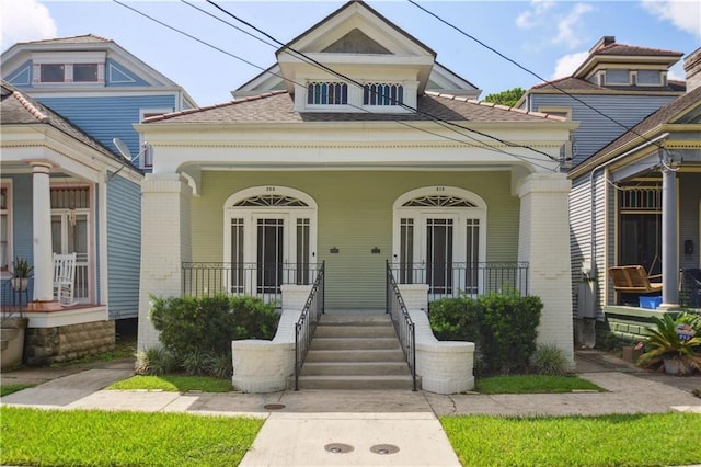 20810 S Scott St, New Orleans, LA 70119 - view of front of home with covered porch, brick siding, and roof with shingles